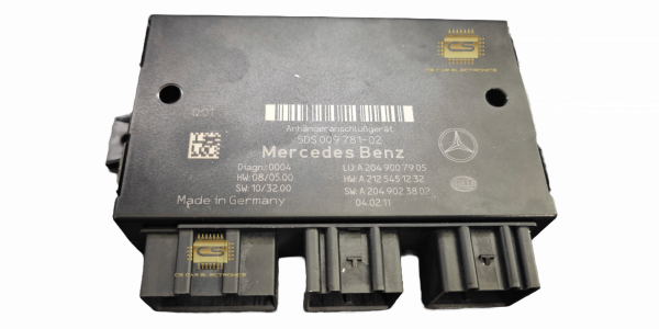 Ein Anhängeranschlussgerät von Mercedes in Nahaufnahme: Das schwarze Kunststoffgehäuse mit mehreren Steckverbindungen sorgt für eine sichere elektrische Verbindung zwischen Fahrzeug und Anhänger. Es ist an der Heckpartie eines Mercedes-Fahrzeugs montiert und ermöglicht die Übertragung von Signalen und Strom.